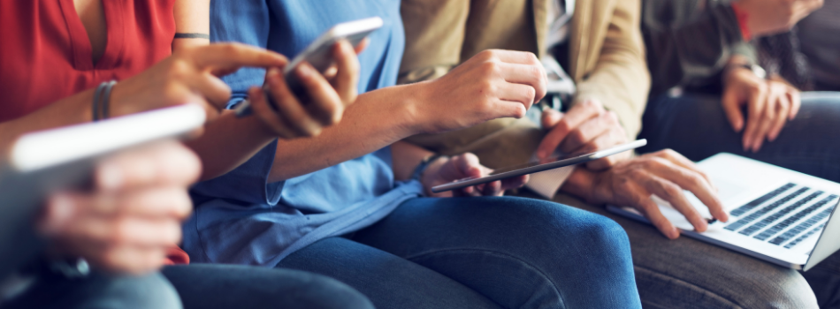 Close-up of people holding different kinds of electronic devices.
