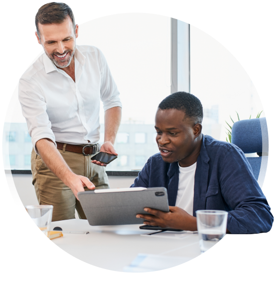 two people in an office looking at a tablet